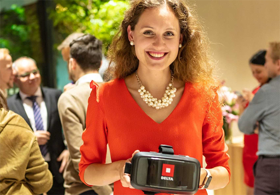 usmiata žena drží v ruke virtuálne okuliare
